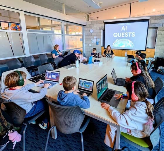 Tamariki at laptops with headphones during an AI for Kids workshop